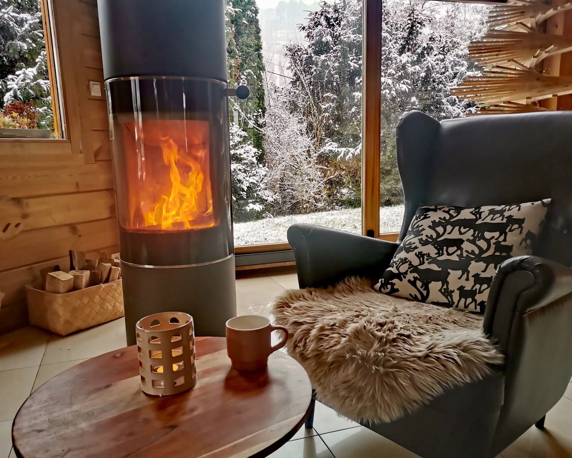 Large living room with wood-burning stove in a Finnish log chalet in Orbey