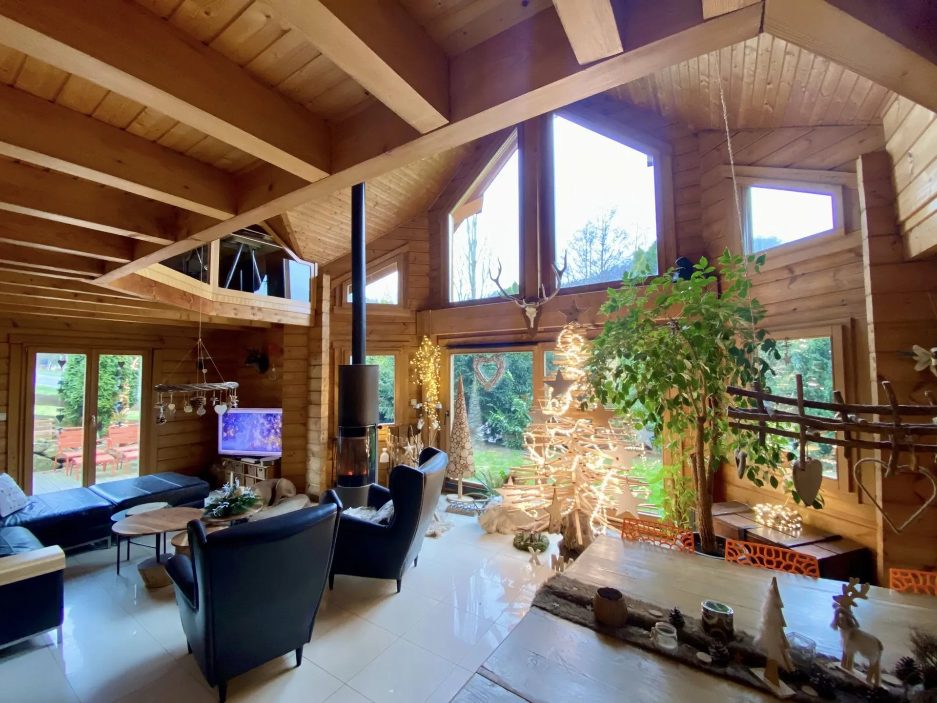 Bright living room with wood-burning stove in a Finnish log chalet in Orbey